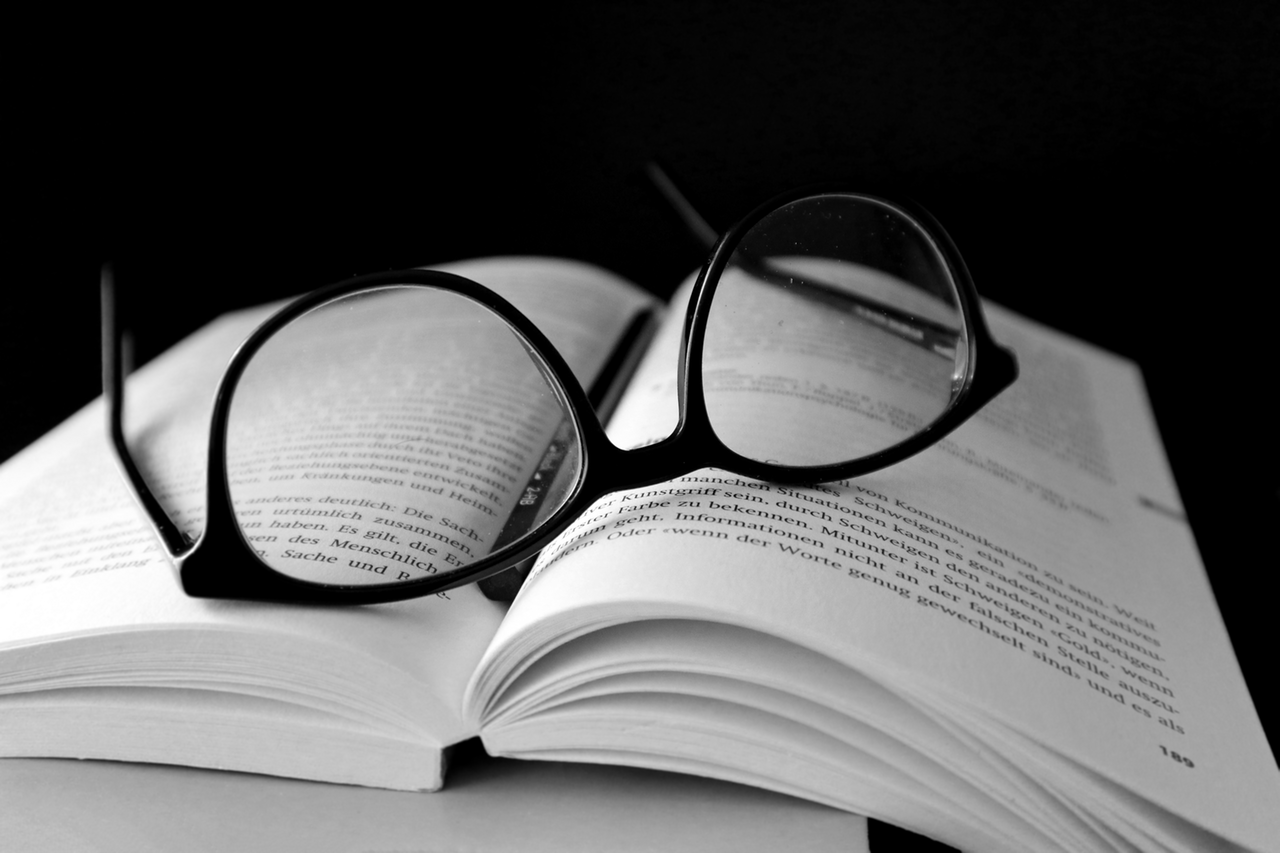 black and white picture of a glass on top of a book